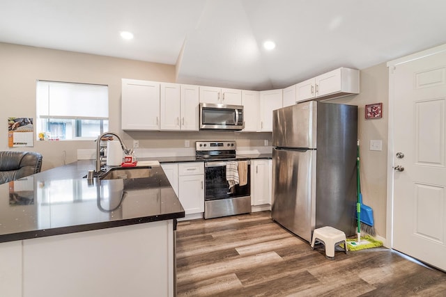 2213 E E Gordon Ave, Spokane, WA 99207 - kitchen with appliances with stainless steel finishes, a sink, wood finished floors, white cabinets, and recessed lighting