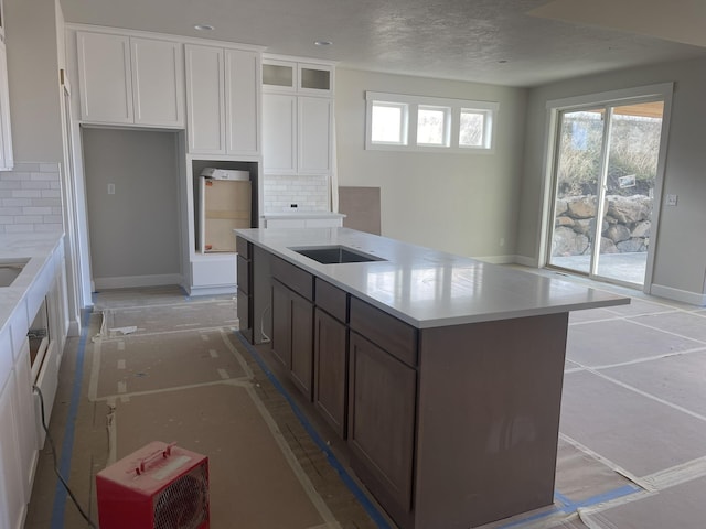 kitchen featuring backsplash, white cabinetry, and a kitchen island