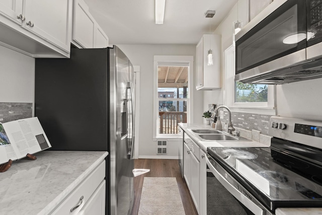 kitchen featuring white cabinets, dark hardwood / wood-style floors, appliances with stainless steel finishes, and plenty of natural light