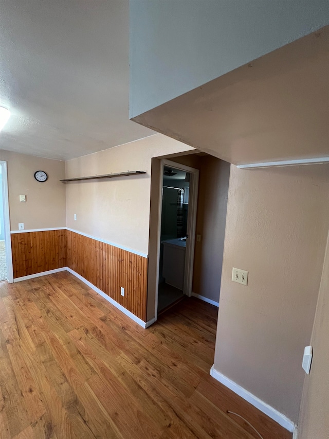 empty room featuring wooden walls and hardwood / wood-style floors