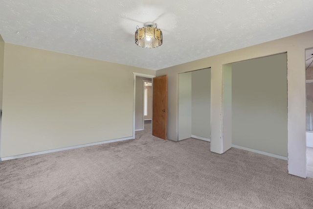 unfurnished bedroom with light colored carpet and a textured ceiling