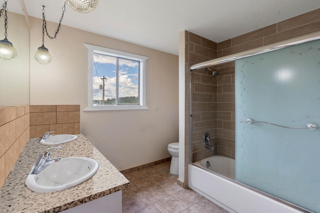 full bathroom with tiled shower / bath combo, tile patterned flooring, vanity, and toilet