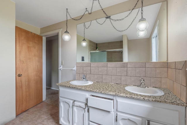 bathroom with tile patterned floors, vanity, a shower with shower door, and decorative backsplash