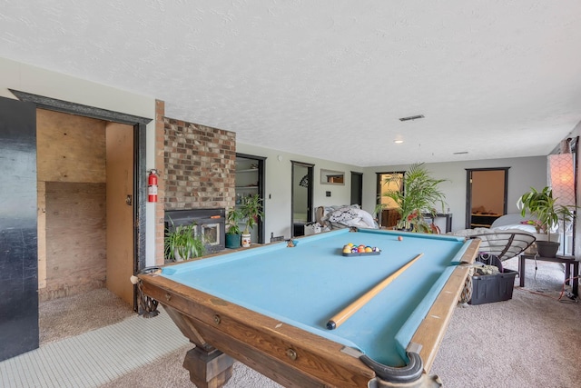 game room with a textured ceiling, pool table, and carpet