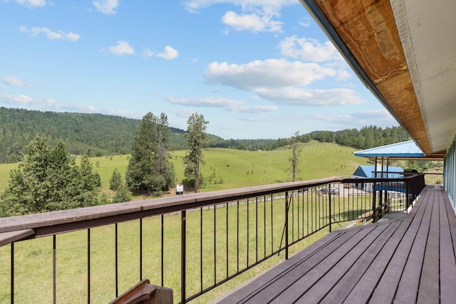 wooden deck with a lawn and a rural view