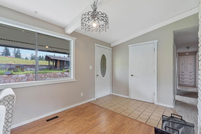 foyer entrance featuring hardwood / wood-style flooring and lofted ceiling with beams