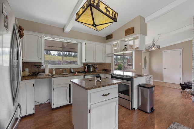 kitchen featuring lofted ceiling with beams, a center island, stainless steel appliances, and white cabinets