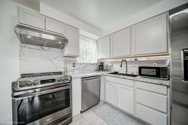 kitchen featuring light stone counters, sink, white cabinets, stainless steel appliances, and exhaust hood