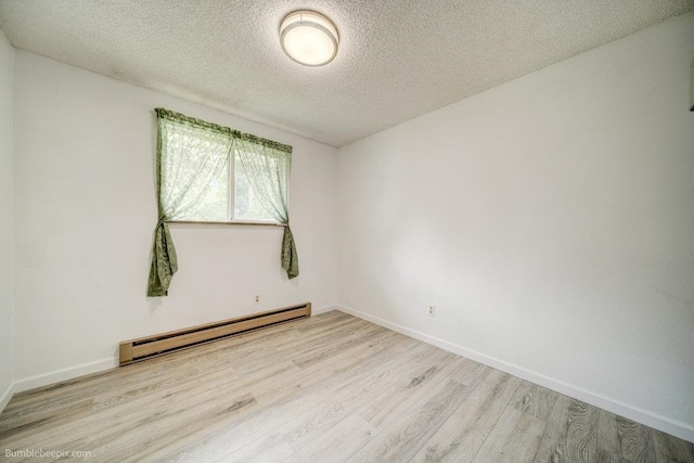 spare room with a textured ceiling, light hardwood / wood-style floors, and a baseboard radiator