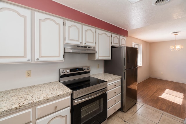 kitchen with white cabinets, stainless steel appliances, a textured ceiling, an inviting chandelier, and light hardwood / wood-style flooring