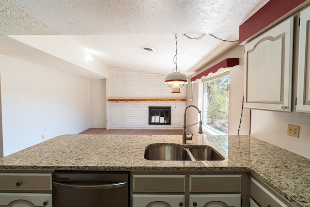 kitchen featuring sink, stainless steel dishwasher, a textured ceiling, gray cabinets, and light stone countertops