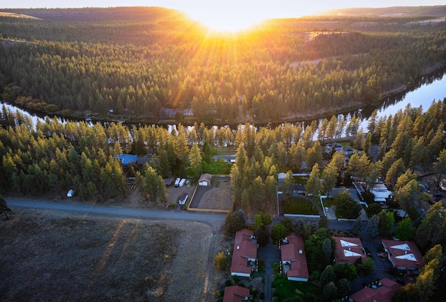 aerial view at dusk featuring a water view