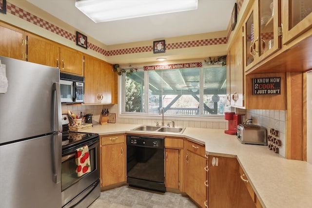 kitchen featuring backsplash, black appliances, and sink