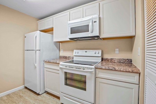 kitchen featuring white appliances and white cabinetry