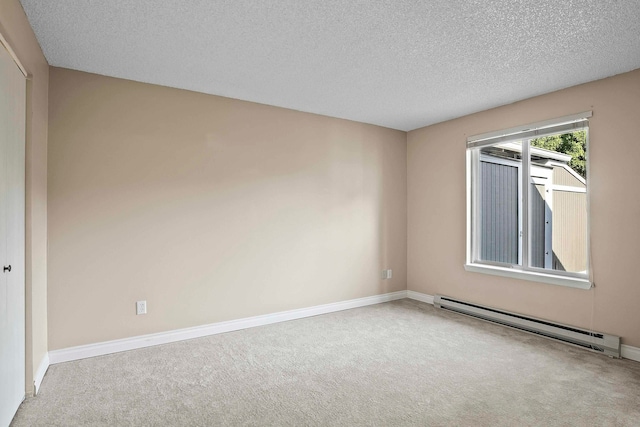 empty room featuring a textured ceiling, carpet flooring, and baseboard heating