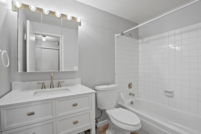 full bathroom featuring tiled shower / bath combo, vanity, and toilet