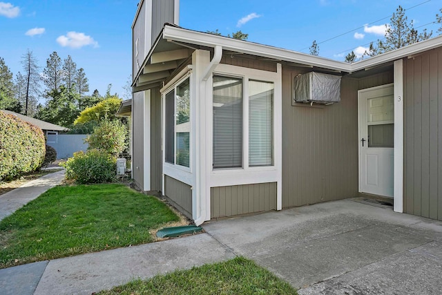 view of side of home with a yard and a patio