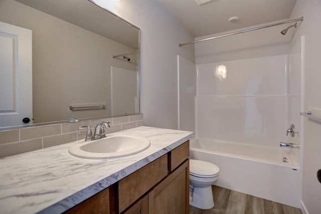 full bathroom featuring tub / shower combination, backsplash, vanity, wood-type flooring, and toilet