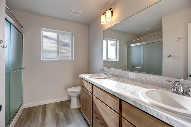 bathroom with vanity, wood-type flooring, a shower with shower door, and toilet