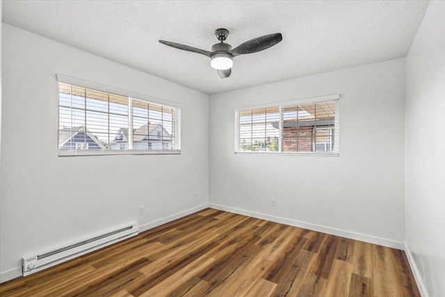 unfurnished room with a textured ceiling, dark wood-type flooring, a baseboard heating unit, and ceiling fan