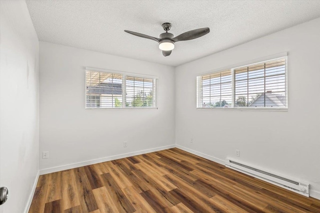 spare room featuring a baseboard heating unit, a textured ceiling, ceiling fan, and dark hardwood / wood-style flooring