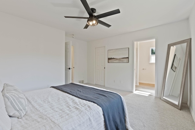 carpeted bedroom featuring ensuite bath and ceiling fan