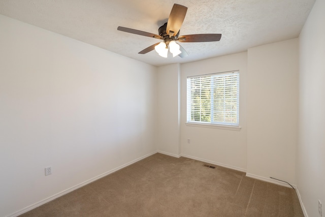 carpeted empty room featuring ceiling fan and a textured ceiling