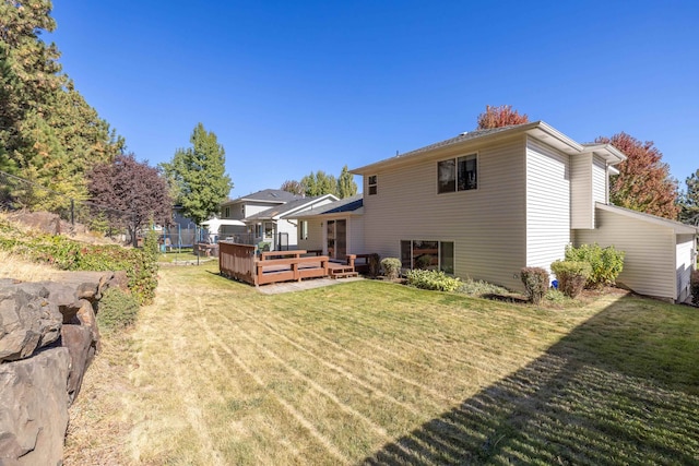 back of house featuring a wooden deck and a yard