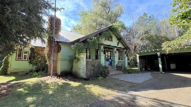 view of front of house with a front lawn, covered porch, and a carport