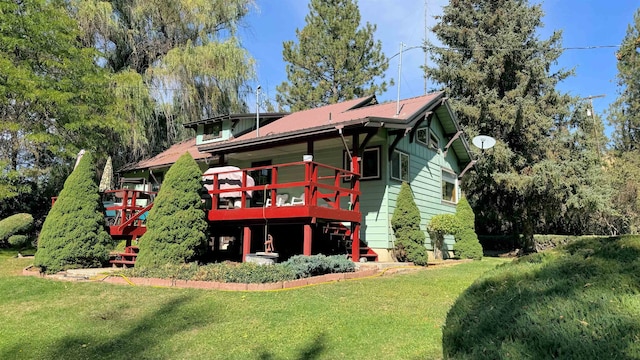 back of property featuring a lawn and a deck