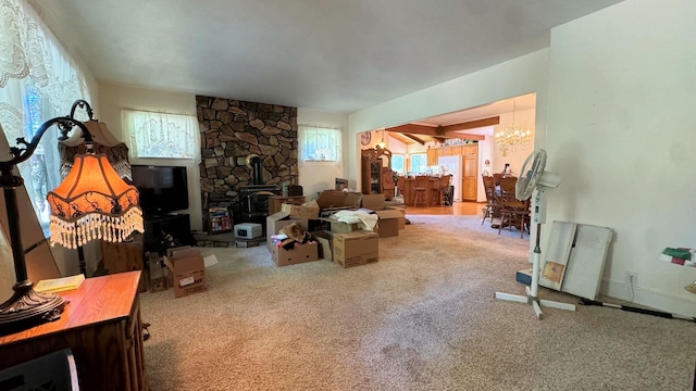 living room featuring carpet floors, a chandelier, and a wood stove