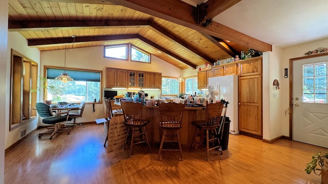 kitchen featuring light wood-type flooring, white refrigerator, kitchen peninsula, vaulted ceiling with beams, and decorative light fixtures