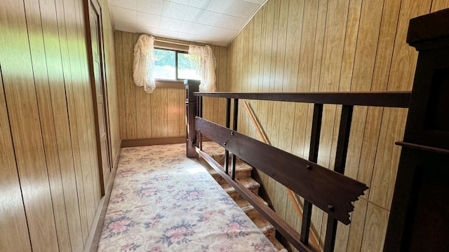 hallway featuring wooden walls