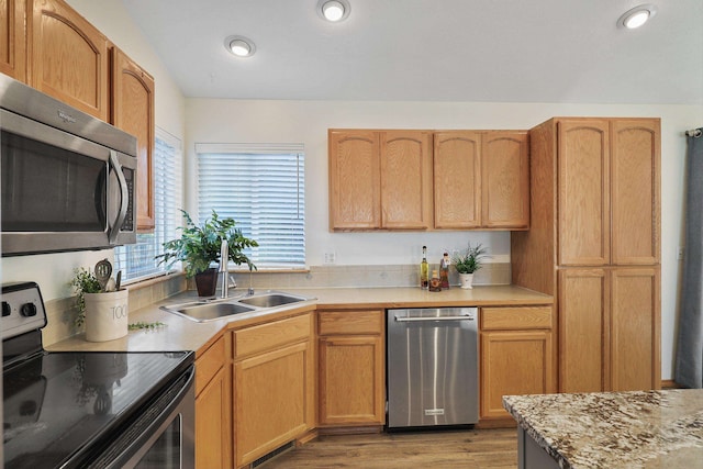 kitchen with stainless steel appliances, hardwood / wood-style flooring, and sink