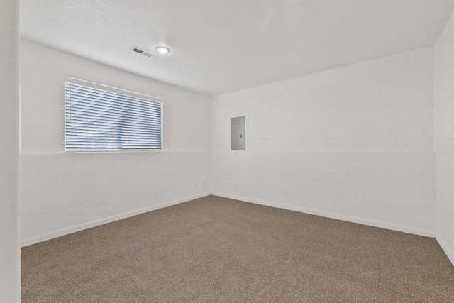 carpeted spare room featuring vaulted ceiling and electric panel