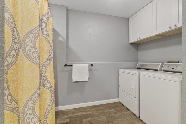 laundry area with cabinets, dark hardwood / wood-style flooring, and washing machine and clothes dryer