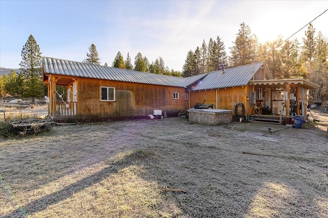 rear view of house featuring a hot tub