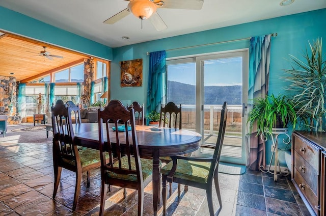 dining space featuring ceiling fan, wooden ceiling, and a mountain view