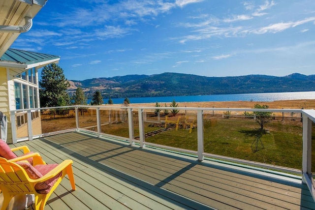 wooden terrace featuring a water and mountain view