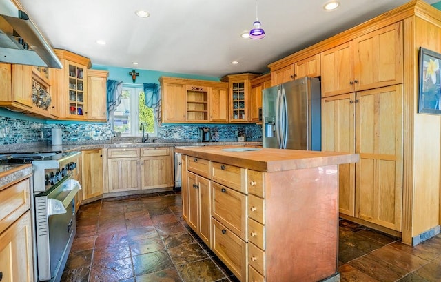 kitchen featuring backsplash, hanging light fixtures, a kitchen island, exhaust hood, and appliances with stainless steel finishes