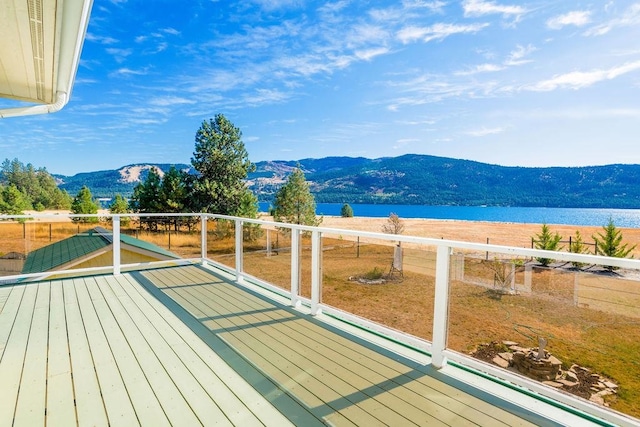 wooden terrace featuring a water and mountain view