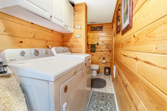 washroom featuring washer and clothes dryer and wood walls