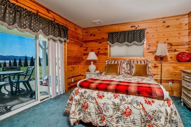 carpeted bedroom featuring access to outside, wood walls, and a mountain view