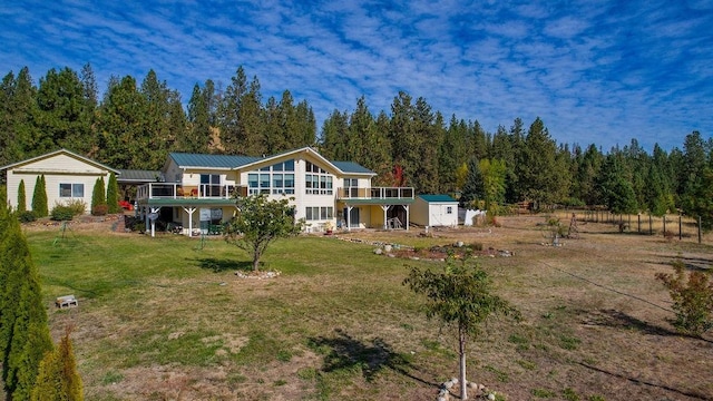 back of property featuring a yard, a wooden deck, and a storage unit