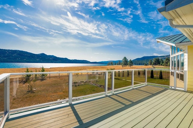 wooden deck featuring a water and mountain view