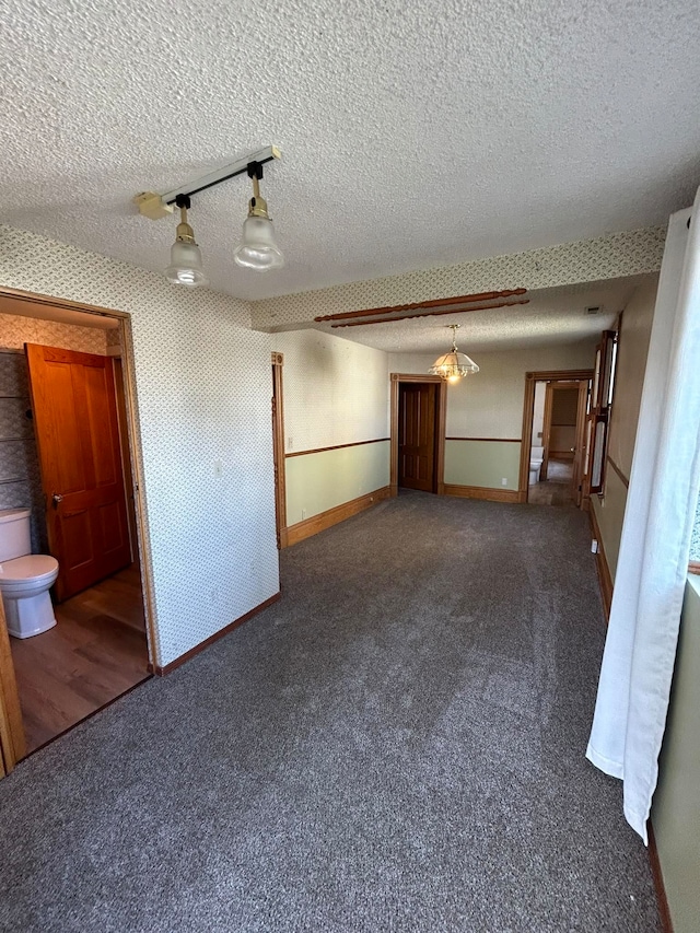 carpeted empty room featuring a textured ceiling