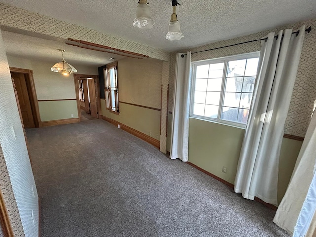 carpeted empty room featuring a textured ceiling