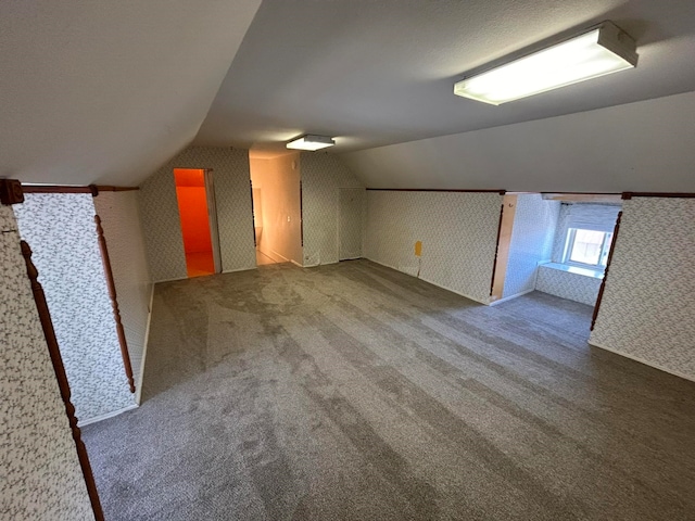 bonus room with carpet floors and lofted ceiling