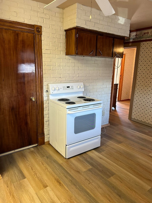 kitchen with dark brown cabinets, light hardwood / wood-style floors, white range with electric cooktop, and ceiling fan