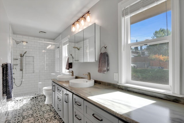 bathroom featuring vanity, walk in shower, a healthy amount of sunlight, and toilet